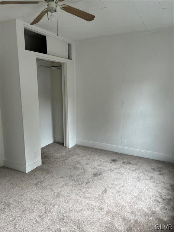 unfurnished bedroom featuring carpet, ceiling fan, and a closet