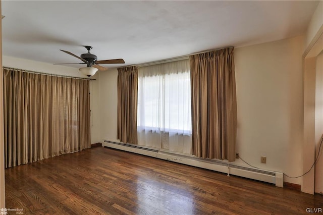 spare room featuring ceiling fan, baseboard heating, and dark hardwood / wood-style flooring