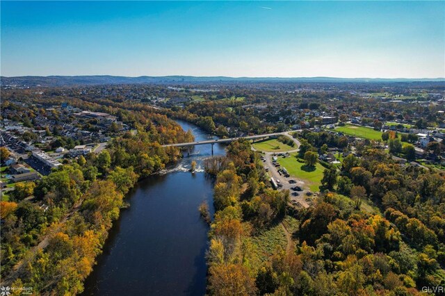aerial view of property and surrounding area featuring a large body of water and a notable bridge