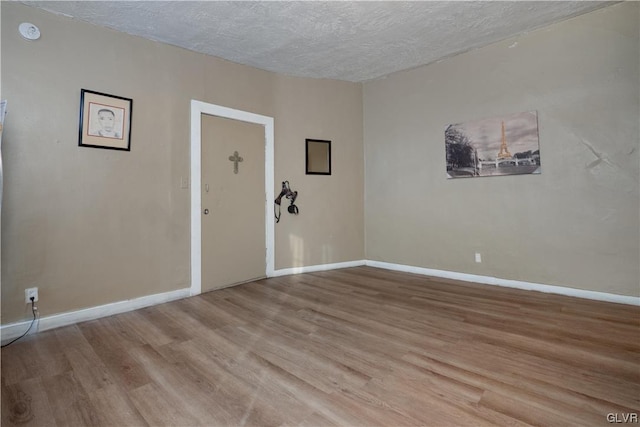 spare room with light hardwood / wood-style flooring and a textured ceiling