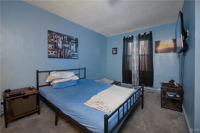 bedroom with a textured ceiling and dark carpet