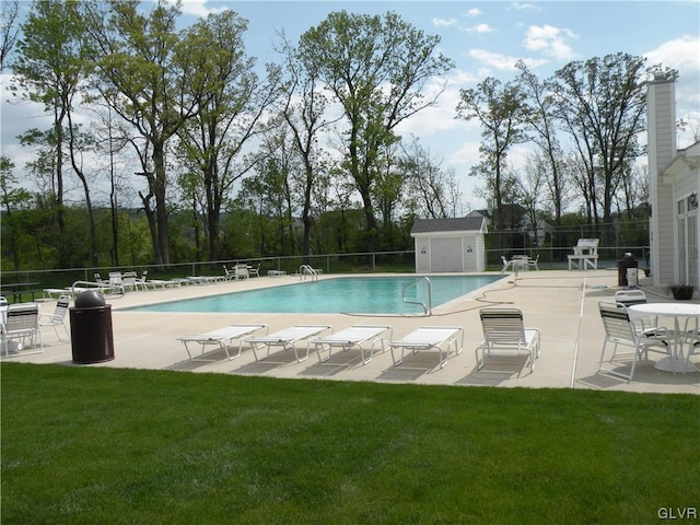 view of swimming pool with a patio area and a yard