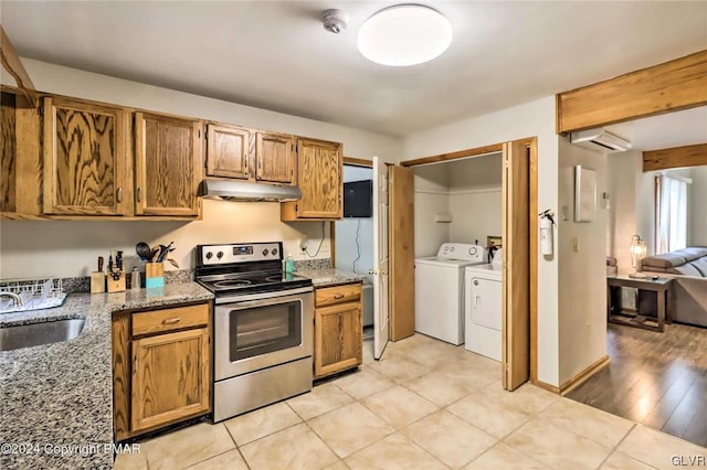 kitchen featuring sink, stainless steel electric range, stone counters, separate washer and dryer, and light hardwood / wood-style floors