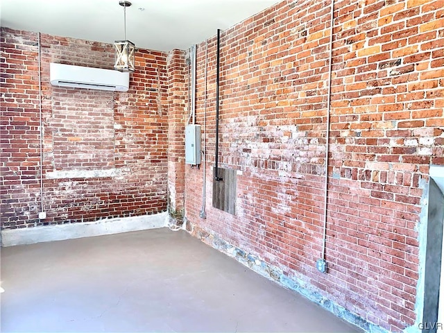 empty room with concrete flooring, brick wall, electric panel, and a wall mounted air conditioner