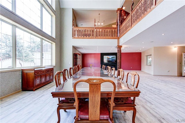 dining space with light wood-type flooring and a high ceiling