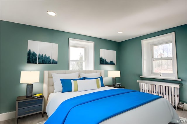 bedroom with radiator, carpet flooring, and multiple windows