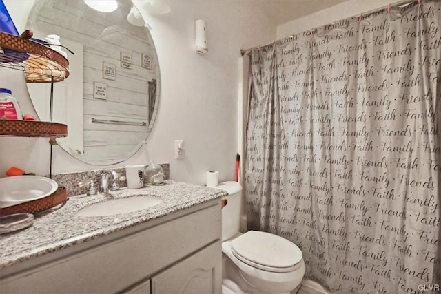 bathroom featuring vanity, toilet, and a shower with shower curtain