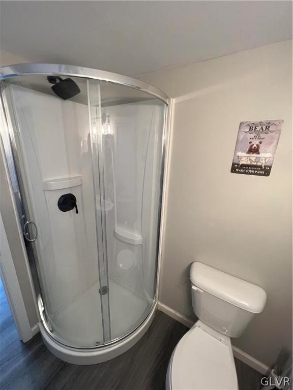 bathroom with a shower with shower door, toilet, and hardwood / wood-style flooring