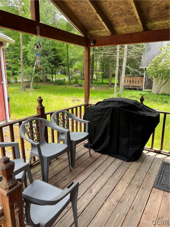 wooden deck with a yard and area for grilling