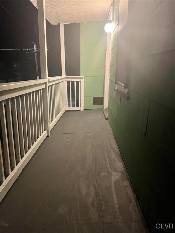 hall with concrete flooring and a textured ceiling