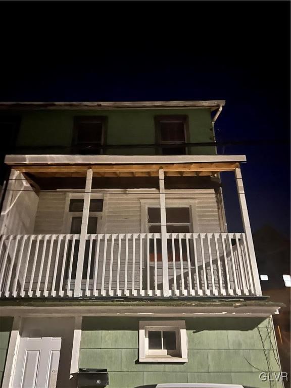 property exterior at twilight with a balcony