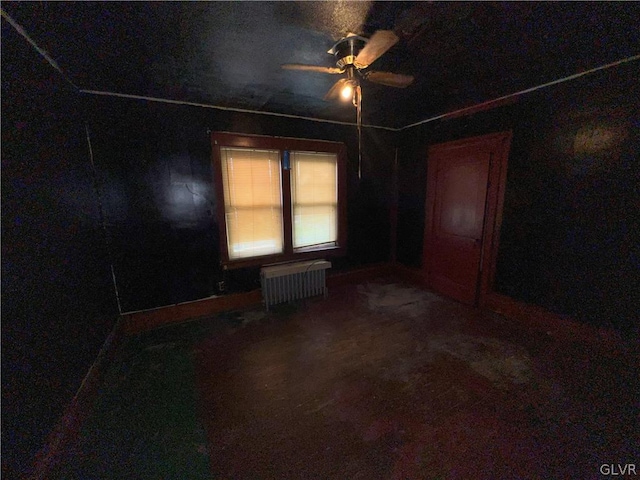 spare room with carpet floors, ceiling fan, and radiator heating unit