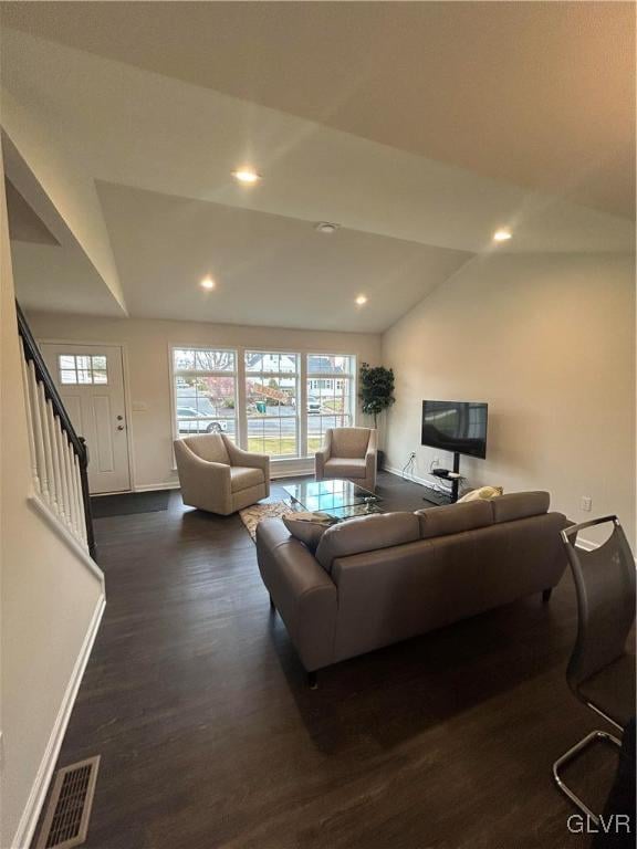 living room featuring dark wood-type flooring and vaulted ceiling