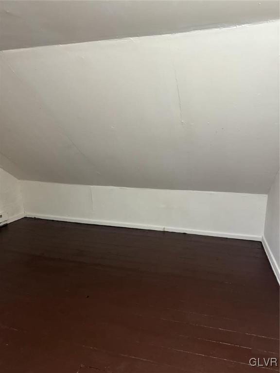 bonus room with lofted ceiling and dark wood-type flooring