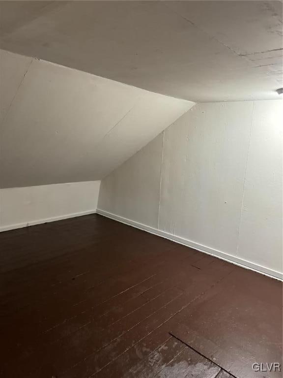 bonus room featuring lofted ceiling and dark hardwood / wood-style flooring