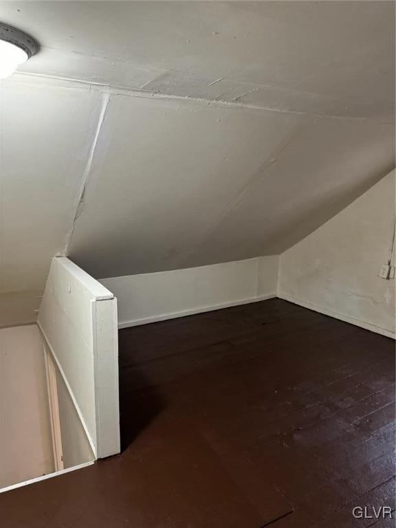 bonus room featuring vaulted ceiling and dark hardwood / wood-style flooring