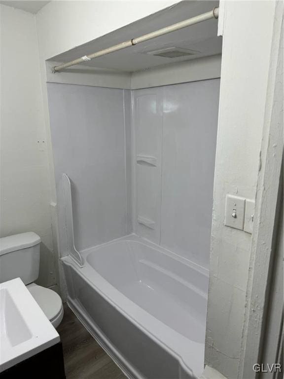 full bathroom featuring hardwood / wood-style floors, bathing tub / shower combination, vanity, and toilet