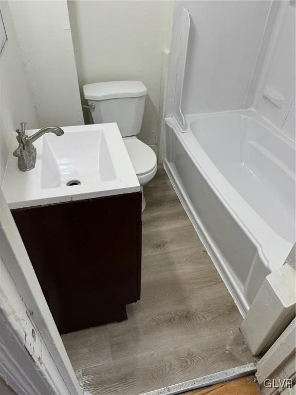 full bathroom with tub / shower combination, hardwood / wood-style floors, vanity, and toilet