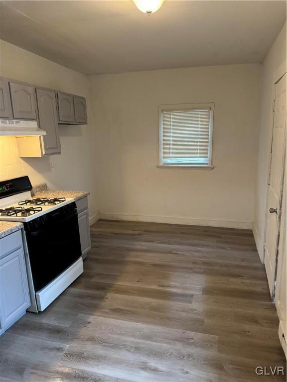 kitchen featuring dark wood-type flooring, white range with gas cooktop, and gray cabinetry