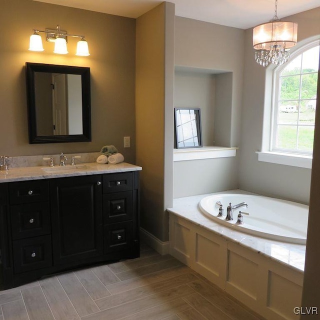 bathroom with vanity, a bathtub, and a notable chandelier