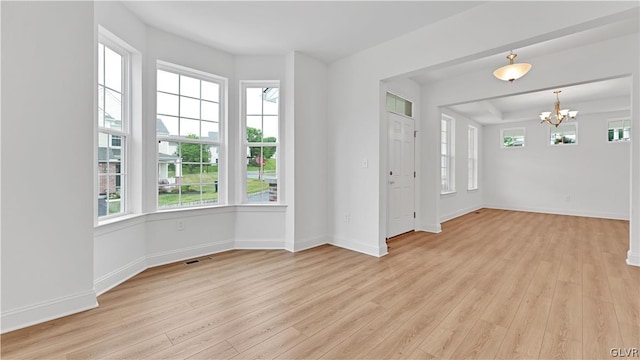 foyer featuring light wood-type flooring and an inviting chandelier