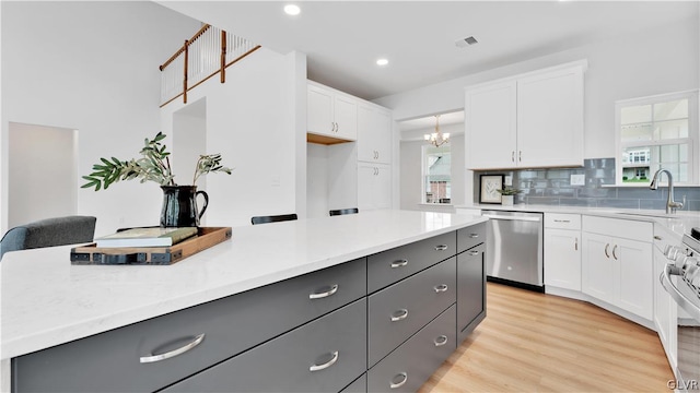 kitchen with light hardwood / wood-style flooring, tasteful backsplash, stainless steel appliances, white cabinets, and sink