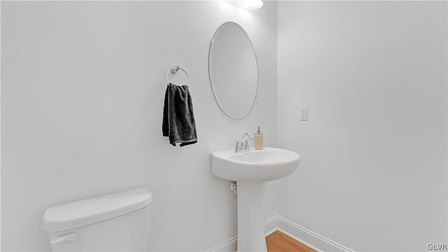 bathroom with toilet and hardwood / wood-style floors