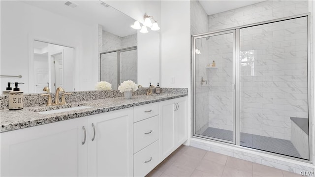 bathroom featuring double vanity, walk in shower, and tile patterned floors