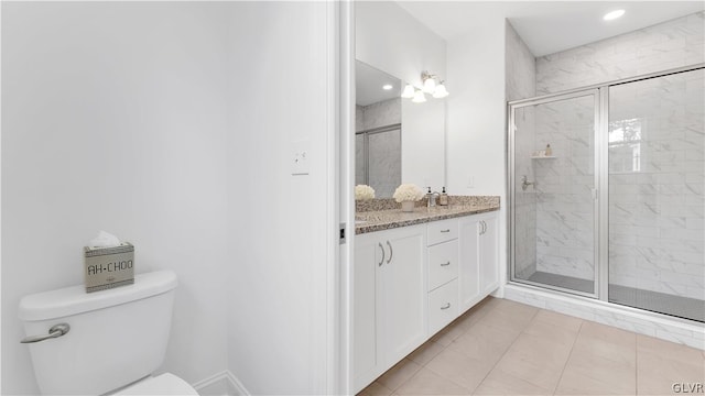 bathroom with tile patterned floors, a shower with door, toilet, and vanity