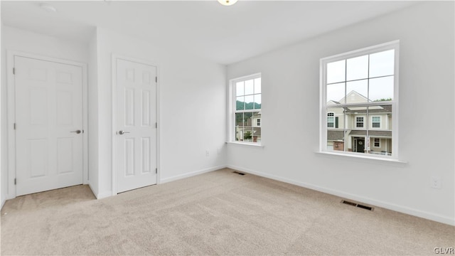 unfurnished bedroom featuring light carpet