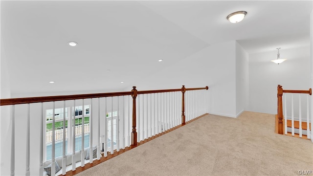 hallway featuring lofted ceiling and carpet