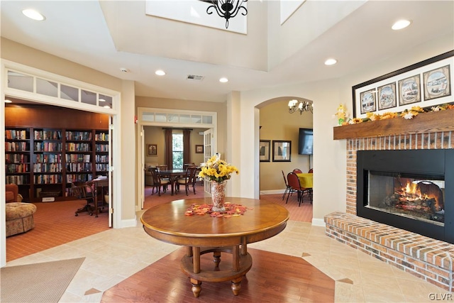 tiled living room featuring a brick fireplace