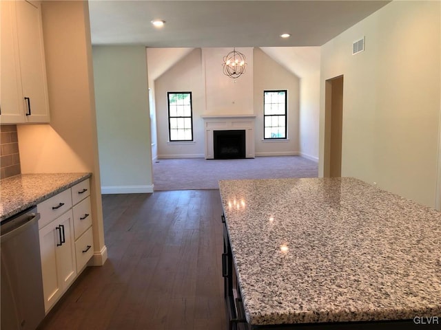 kitchen featuring a kitchen island, decorative light fixtures, dishwasher, white cabinets, and light stone counters