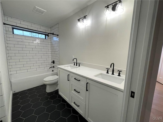 full bathroom featuring tile patterned floors, vanity, toilet, and tiled shower / bath combo