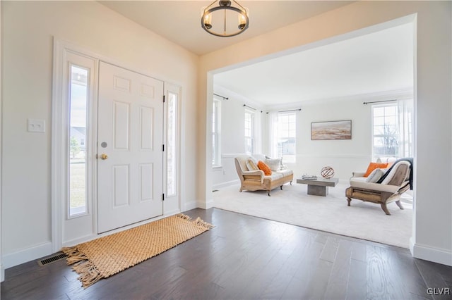 entrance foyer with dark wood-type flooring and an inviting chandelier