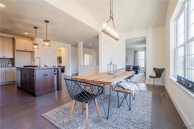 dining area with lofted ceiling, dark hardwood / wood-style flooring, and sink