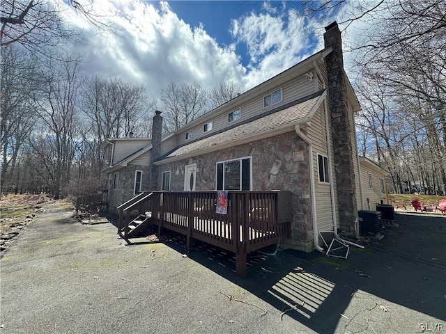 rear view of house featuring a wooden deck