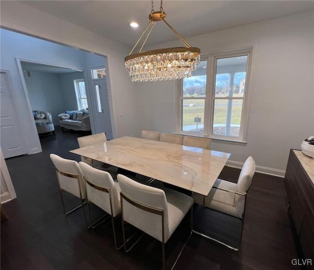 dining space featuring dark hardwood / wood-style floors and a chandelier