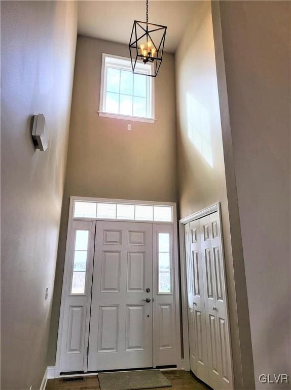 foyer entrance with a notable chandelier and a towering ceiling