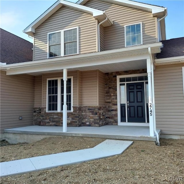 view of exterior entry featuring covered porch