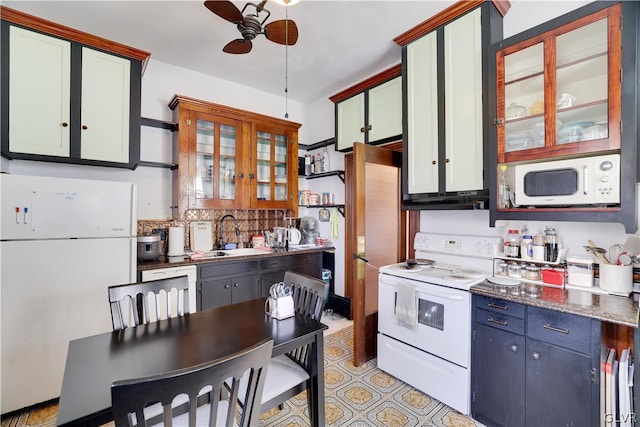 kitchen with tasteful backsplash, a ceiling fan, a sink, dark stone countertops, and white appliances