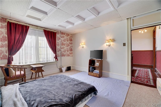 bedroom with coffered ceiling, wainscoting, light colored carpet, and baseboards