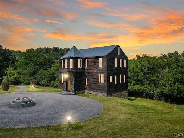 back house at dusk with a yard