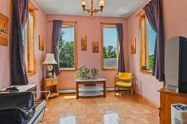 living area featuring baseboard heating, light parquet flooring, and a chandelier