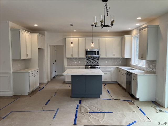 kitchen featuring white cabinets, pendant lighting, appliances with stainless steel finishes, and a center island