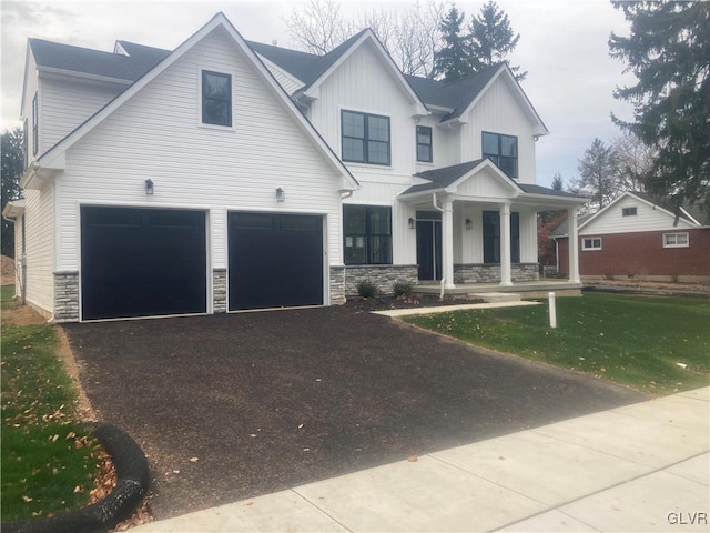 view of front facade with a garage, a front yard, and a porch