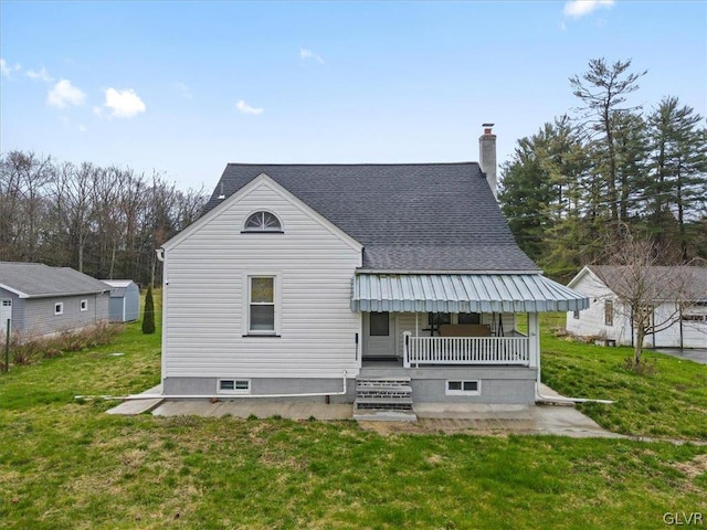 back of property with a yard and covered porch