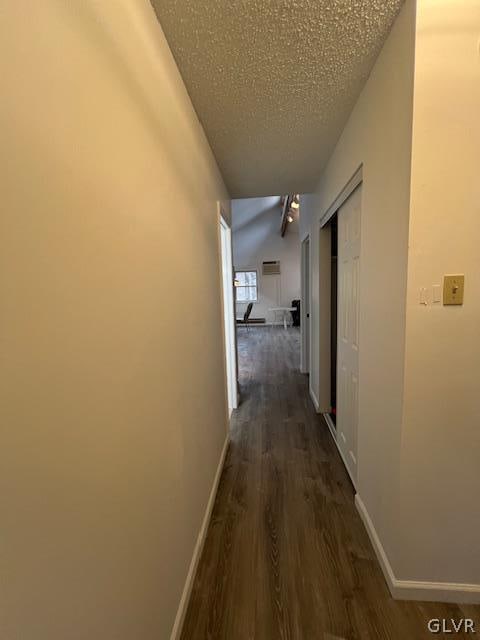 corridor featuring dark hardwood / wood-style flooring and a textured ceiling