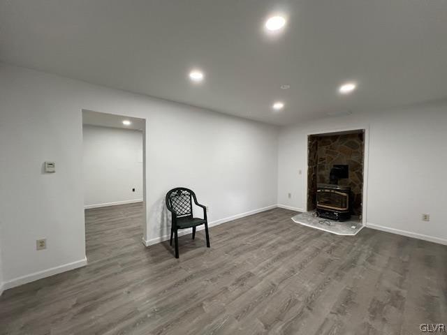 basement featuring a wood stove and dark wood-type flooring