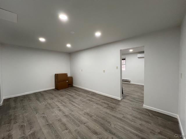 interior space with an AC wall unit and dark hardwood / wood-style floors